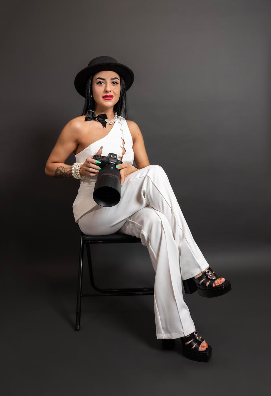 Gabriela Patru, photographer, seated in the studio holding her Canon camera